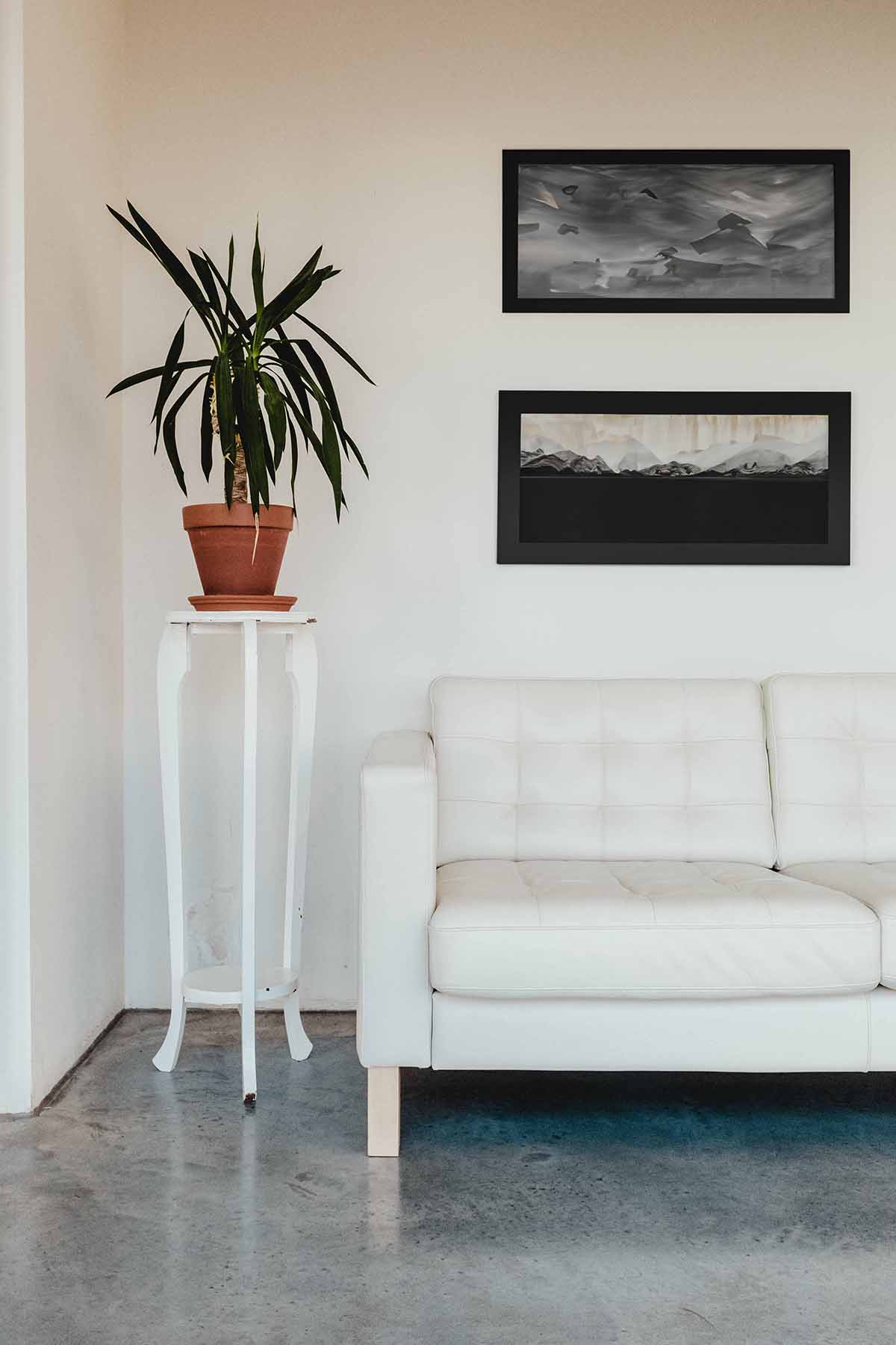 Vertically stacked wall art above sofa